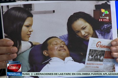 Hugo Chávez lee el periódico Granma con sus hijas desde su hospital en Cuba.